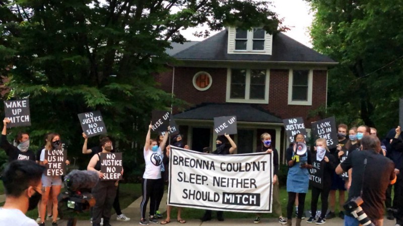 Des militants de Sunrise manifestent devant la maison de Mitch McConnell à KY, tenant une grande pancarte disant "Breonna ne pouvait pas dormir. Mitch non plus ne devrait".