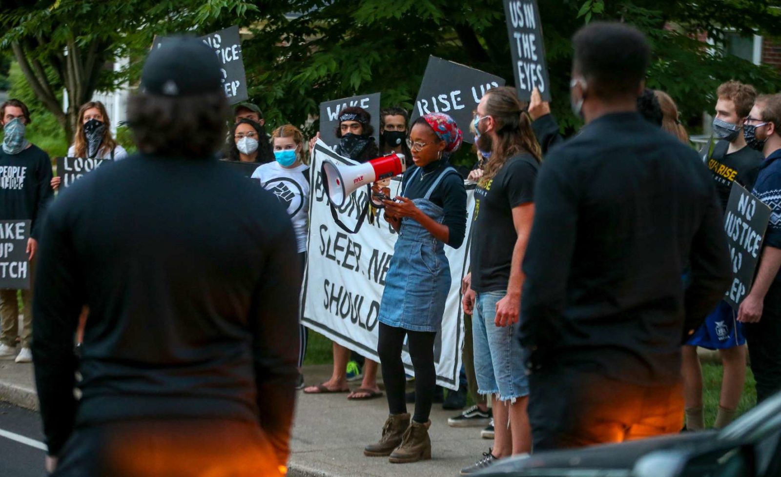 A Sunrise activist speaks into a megaphone while fellow protesters stand in support.