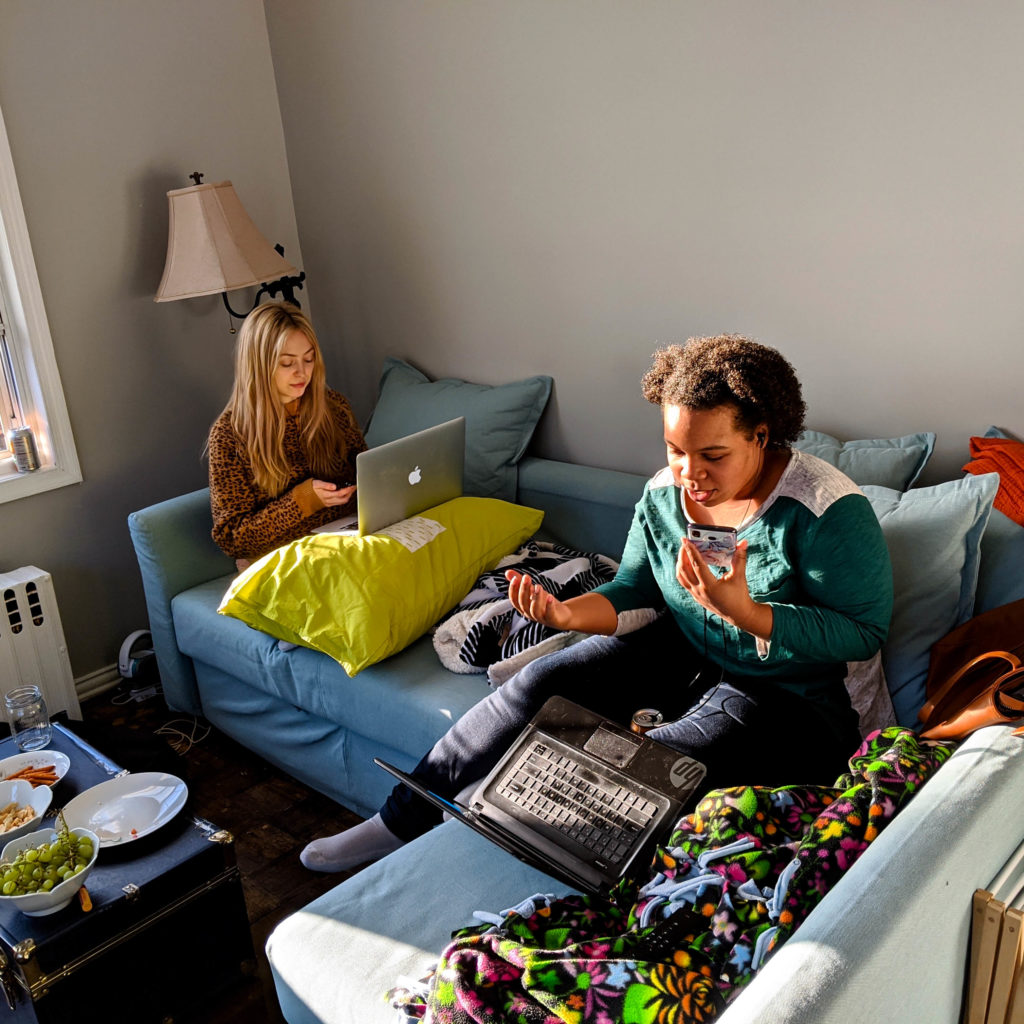 Due persone telefonano sul loro divano, chiamando gli elettori per sostenere i campioni del Green New Deal.
