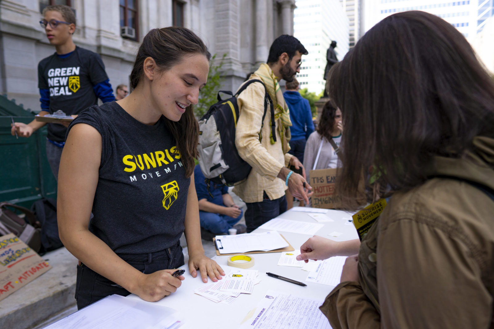 Um organizador do Sunrise fica ao lado de uma mesa para registrar os eleitores durante a greve climática de setembro de 2019.