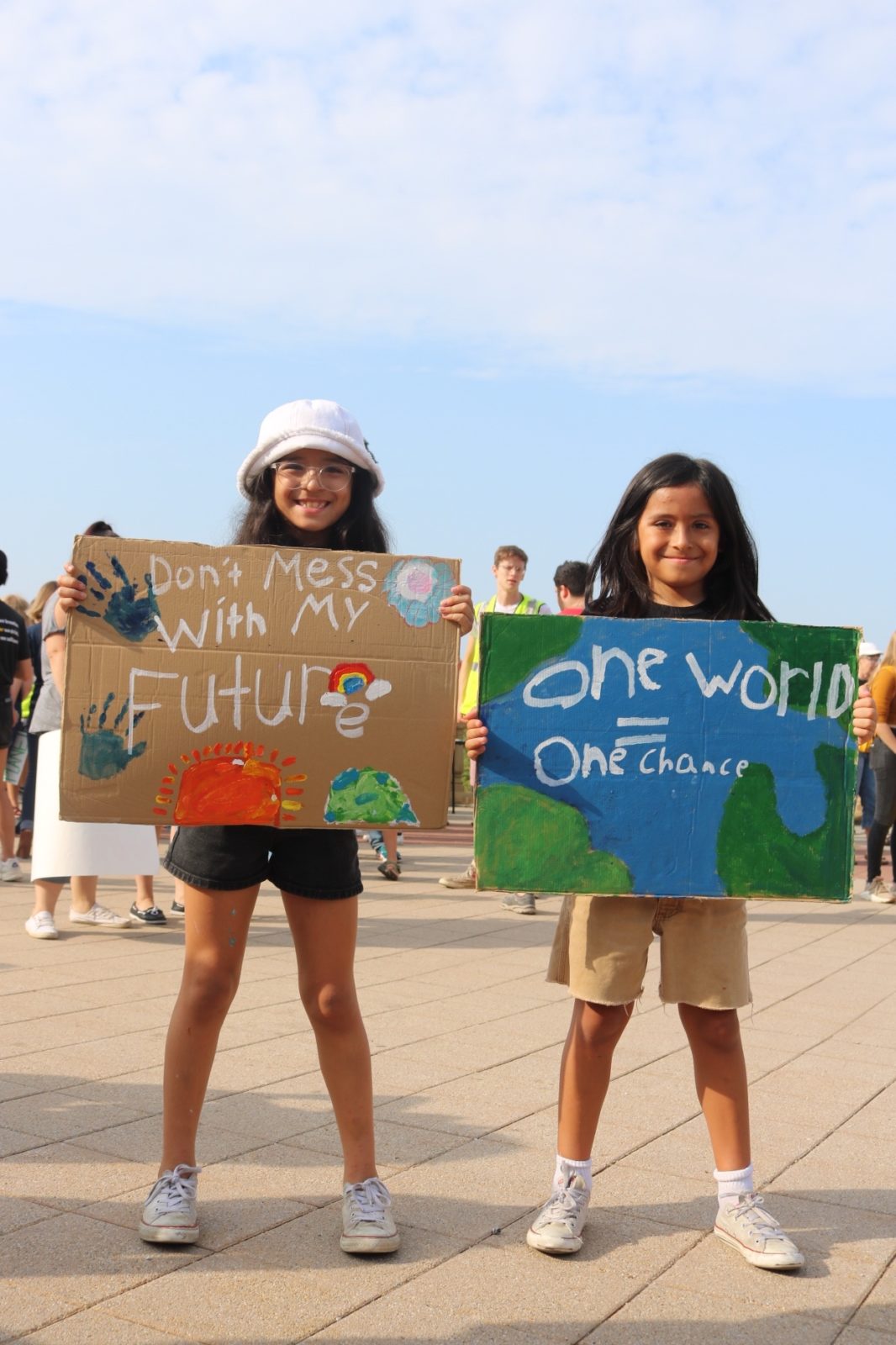Two young activists hold signs saying "Don't mess with my future" and "One world, one chance" during the September 2019 Climate Strike.