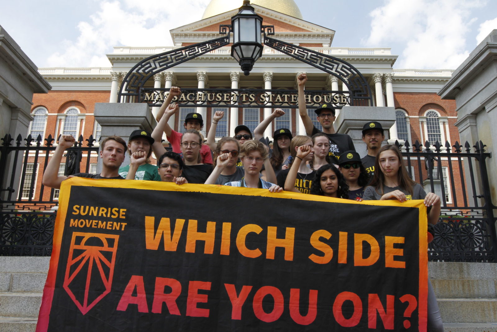 Sunrise Boston activists holding a "Which Side Are You On?" sign as they put pressure on politicians corrupted by the influence of the fossil fuel industry.