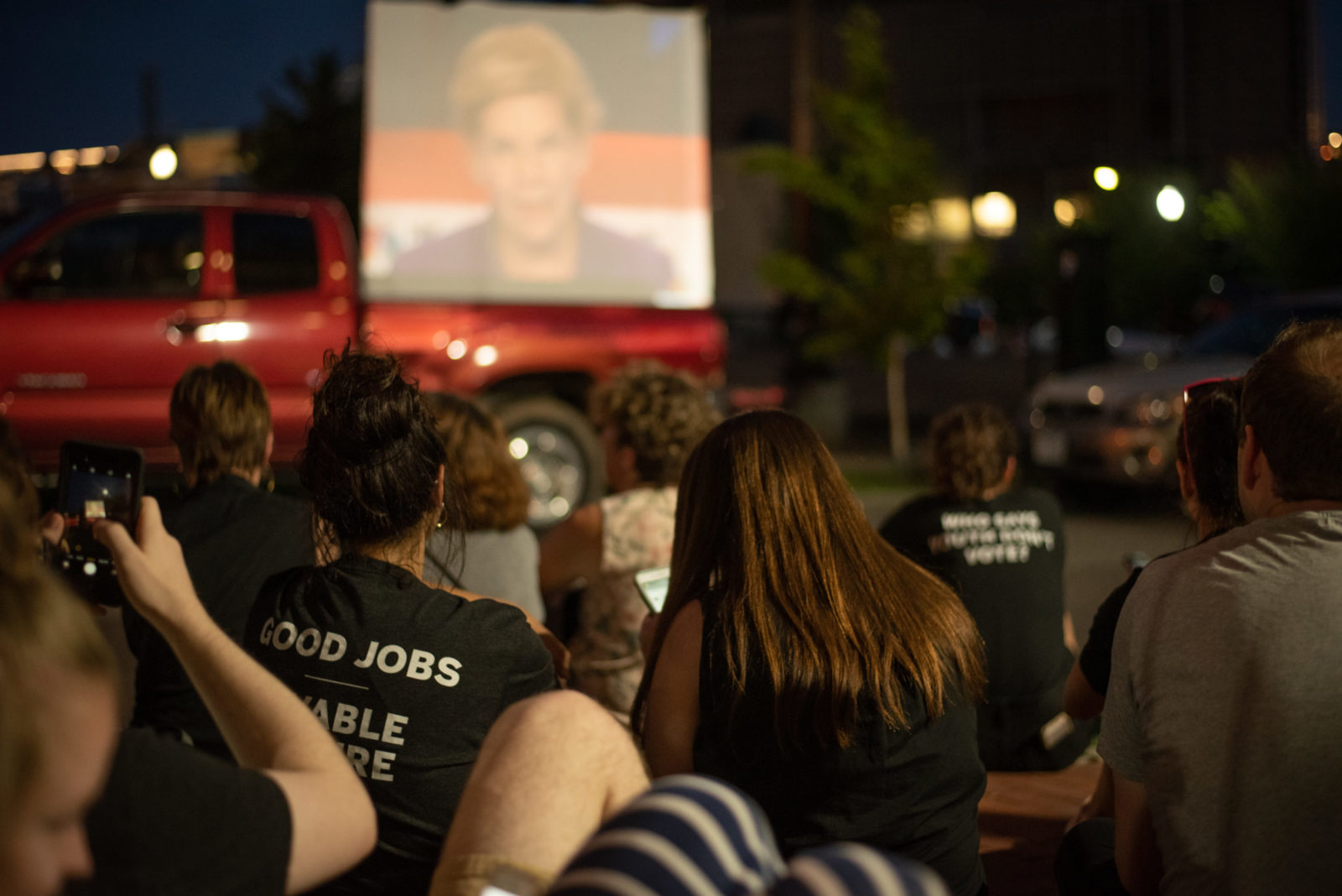 Sunrise Movement activists watch the presidential debate on a screen outside the DNC headquarters in DC during the sit-in.