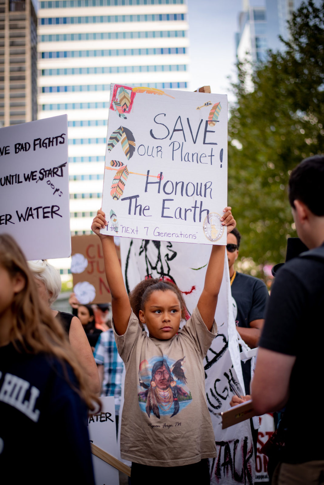 A young activist holds a sign saying "Save our planet. Honour the Earth" during the September 2019 Climate Strike.