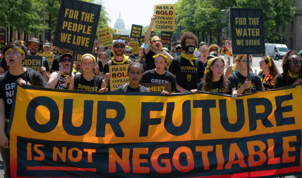 日出者在华盛顿游行，手持横幅，上面写着“我们的未来不可谈判”。