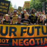 Sunrisers marching in DC holding banenr that reads Our Future is not Negotiable.