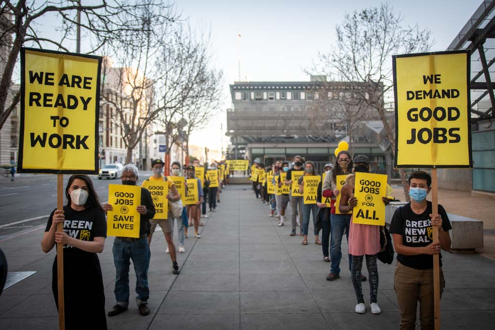 Ativistas segurando cartazes exigindo bons empregos sindicais.